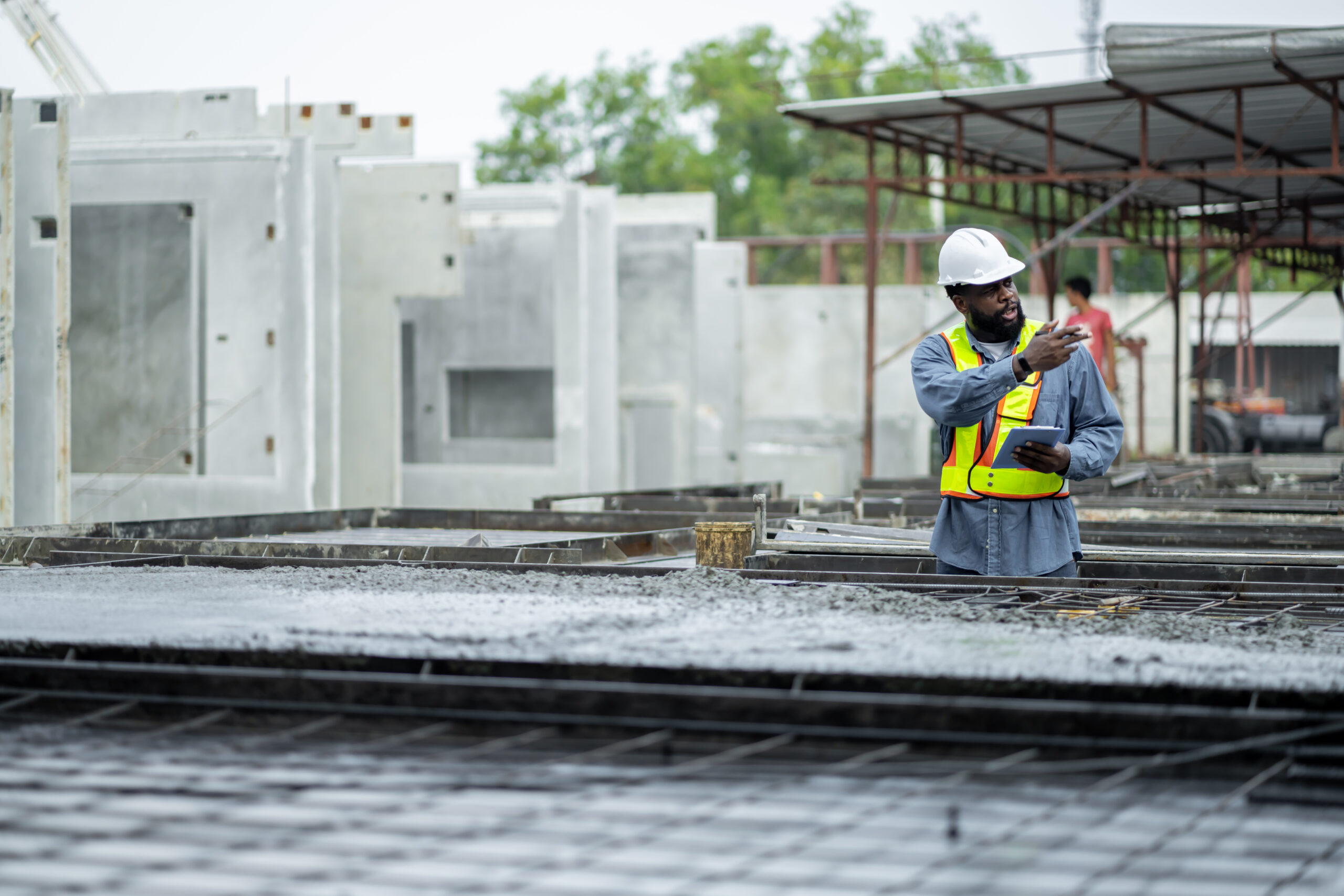 Male engineers are inspecting and controlling the work of the employees and the quality of the manufactured products to meet the standards. In industrial factories producing precast prefabricated walls
